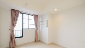 A room with a large window, a metal towel rack, and a tiled floor. - Minimalist 1Br With Extra Room At Evenciio Margonda Apartment (Depok)