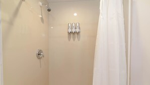A modern bathroom with a shower, toilet, and three hand dryers mounted on the wall. - Modern, stylish, peaceful apartment with a great view! (Buckleys)