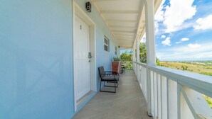 A covered balcony with a door marked '3', a chair, and a table. - Modern, stylish, peaceful apartment with a great view! (Buckleys)