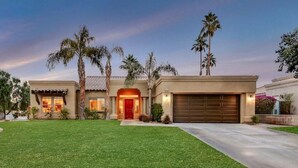 A two-story house with a red door, a garage, and a well-maintained lawn. - Sonrisa Sunshine-Pool,Spa,Walk to BNP 3BD #066685 (La Quinta)