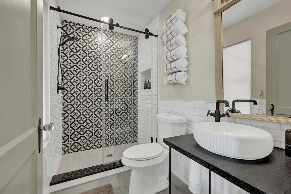 A modern bathroom with a shower, toilet, and sink.