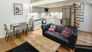 Un appartement moderne comprenant un salon, un coin repas, une kitchenette et un escalier.
