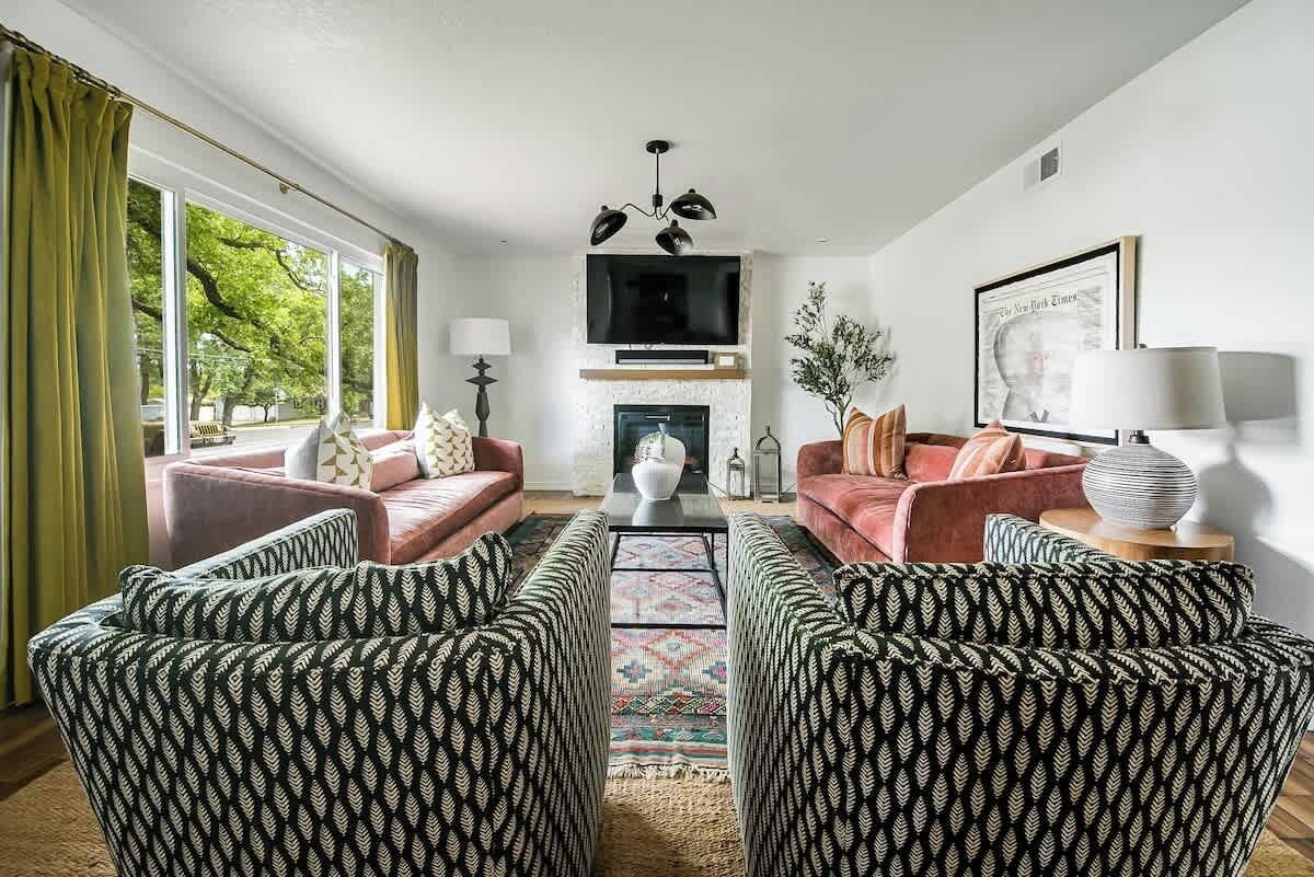 A living room with two sofas, a coffee table, a fireplace, and a television.