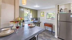 A modern kitchen with a large island, stainless steel appliances, and a view of the outdoors. - Two Unit Oasis With Two Hot Tubs (Fredericksburg)