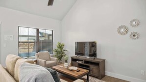 Ein Wohnzimmer mit Sofa, Couchtisch, TV-Möbel und Wanddekoration.