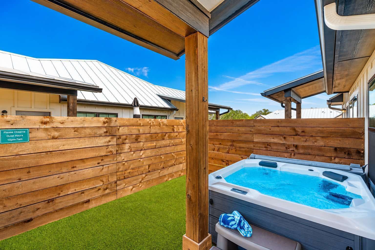 A hot tub with a wooden deck and a sign indicating quiet hours.