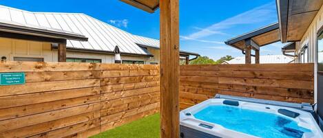 A hot tub with a wooden deck and a sign indicating quiet hours.