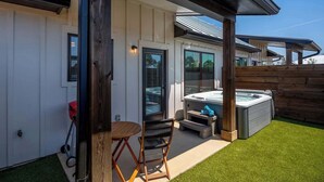 A patio with a hot tub, a table, and chairs. - Fred's Joint With Hot Tub (Fredericksburg)