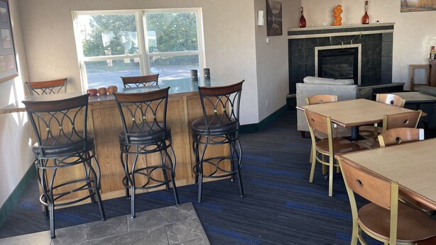 A cozy restaurant with a bar area, seating arrangements, and a fireplace. - Hotel Yuma (Yuma)