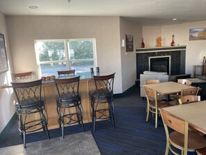 A cozy restaurant with a bar area, seating arrangements, and a fireplace. - Hotel Yuma (Yuma)