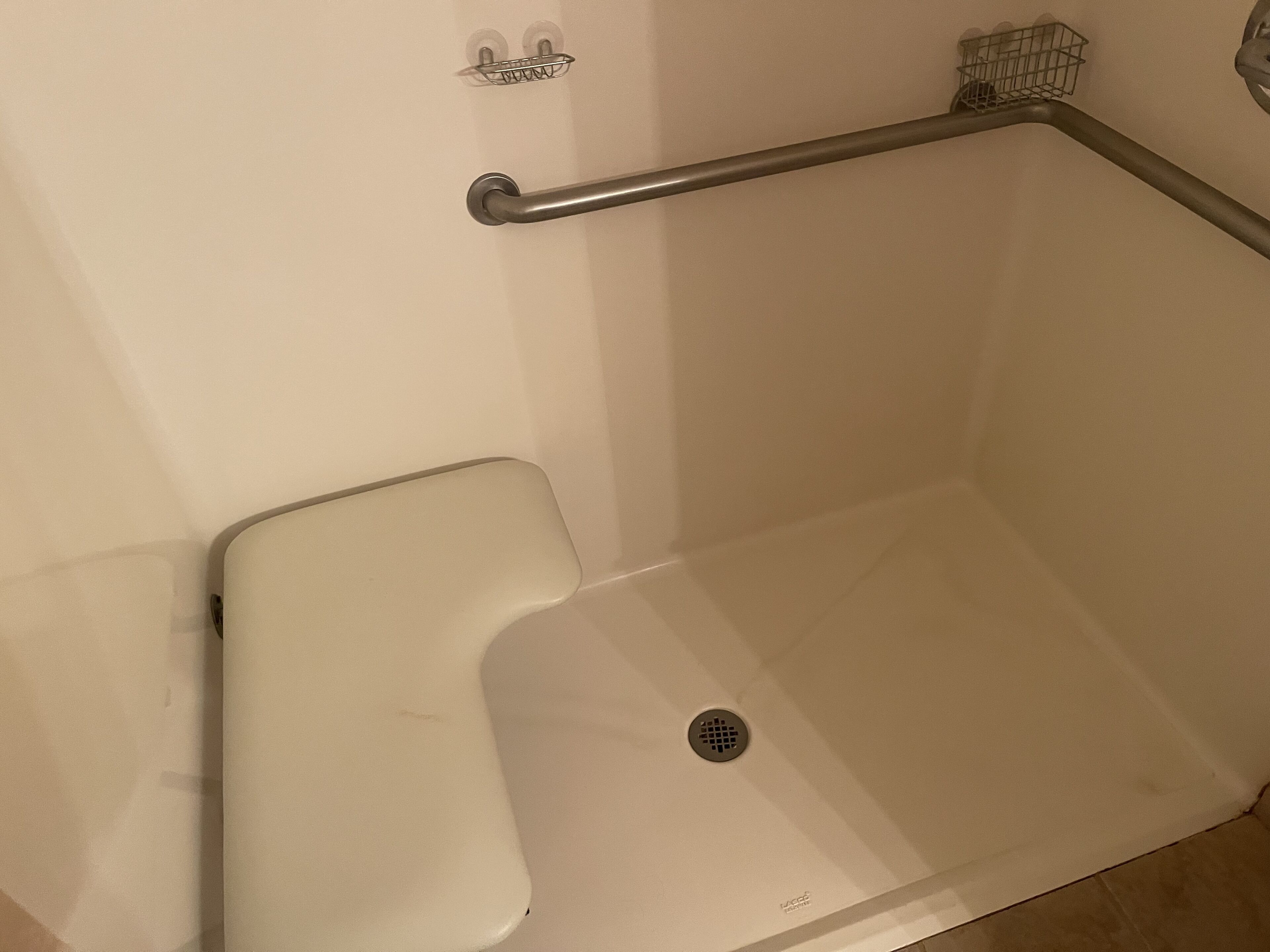 A white bathtub with a grab bar and a showerhead.