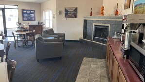 A hotel lobby with a fireplace, seating area, and a coffee machine. - Hotel Yuma (Yuma)