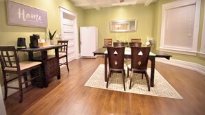 Comedor con mesa, sillas, ventilador de techo y refrigerador.
