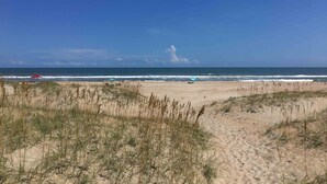 A beach with sand dunes and a clear blue sky. - 7589- Anchored in the Sand - Avon Beach Cottage | 60 Yards to Beach (Avon)