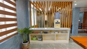 A modern kitchen with a built-in water dispenser, a white cabinet with shelves, and a potted plant. - Life In Santa Maria (Santa Maria)