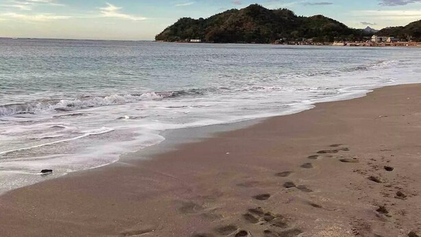 A beach with footprints in the sand and a mountain in the background. - Life In Santa Maria (Santa Maria)