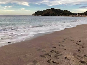 A beach with footprints in the sand and a mountain in the background. - Life In Santa Maria (Santa Maria)
