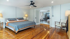A bedroom with a bed, bedside lamps, a ceiling fan, and a wooden floor. - Cherry Street Loft (A) | In the Heart of Downtown Black Mtn! (Black Mountain)