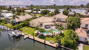 A residential area with houses, a swimming pool, and a dock. - New Listing! Luxury 4BR Canal Home with Pool. Monthly Rental.    (Holmes Beach)