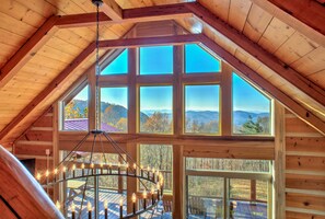 A wooden cabin with a large skylight and a spiral staircase with lights.
