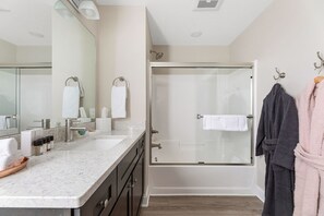 Enjoy a refreshing shower in this bathroom with a glass-enclosed shower and vanity area.