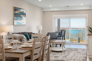 Enjoy meals in this dining area with a table for four and a view of a serene body of water.