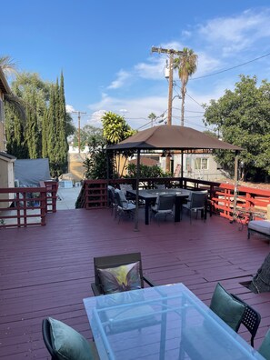 An outdoor patio area with a covered seating area, tables, and chairs.