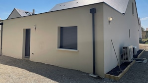 Un edifici modern amb teulada plana, una finestra petita i una porta.