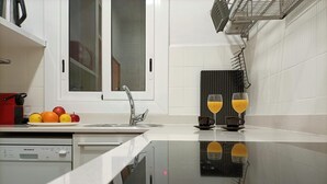 Une cuisine moderne dotée d’un évier en acier inoxydable, d’un égouttoir et d’une fenêtre située au-dessus de l’évier.