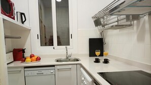 Une cuisine moderne équipée d’un lave-vaisselle, d’un four et d’une plaque de cuisson à induction noire.