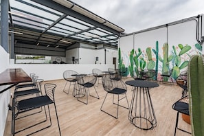 Relax and socialize in this serene outdoor space with comfortable seating and a vibrant mural.