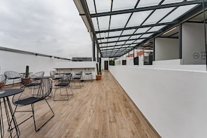 Relax on the rooftop terrace with comfortable seating and lush greenery.
