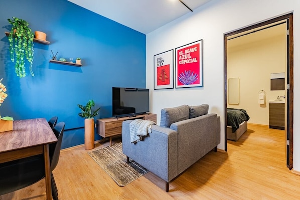Relax in this stylish living room with a comfortable sofa, flat-screen TV, and potted plant.