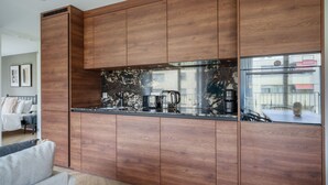 Una cocina moderna con armarios de madera y un salpicadero de mármol negro.