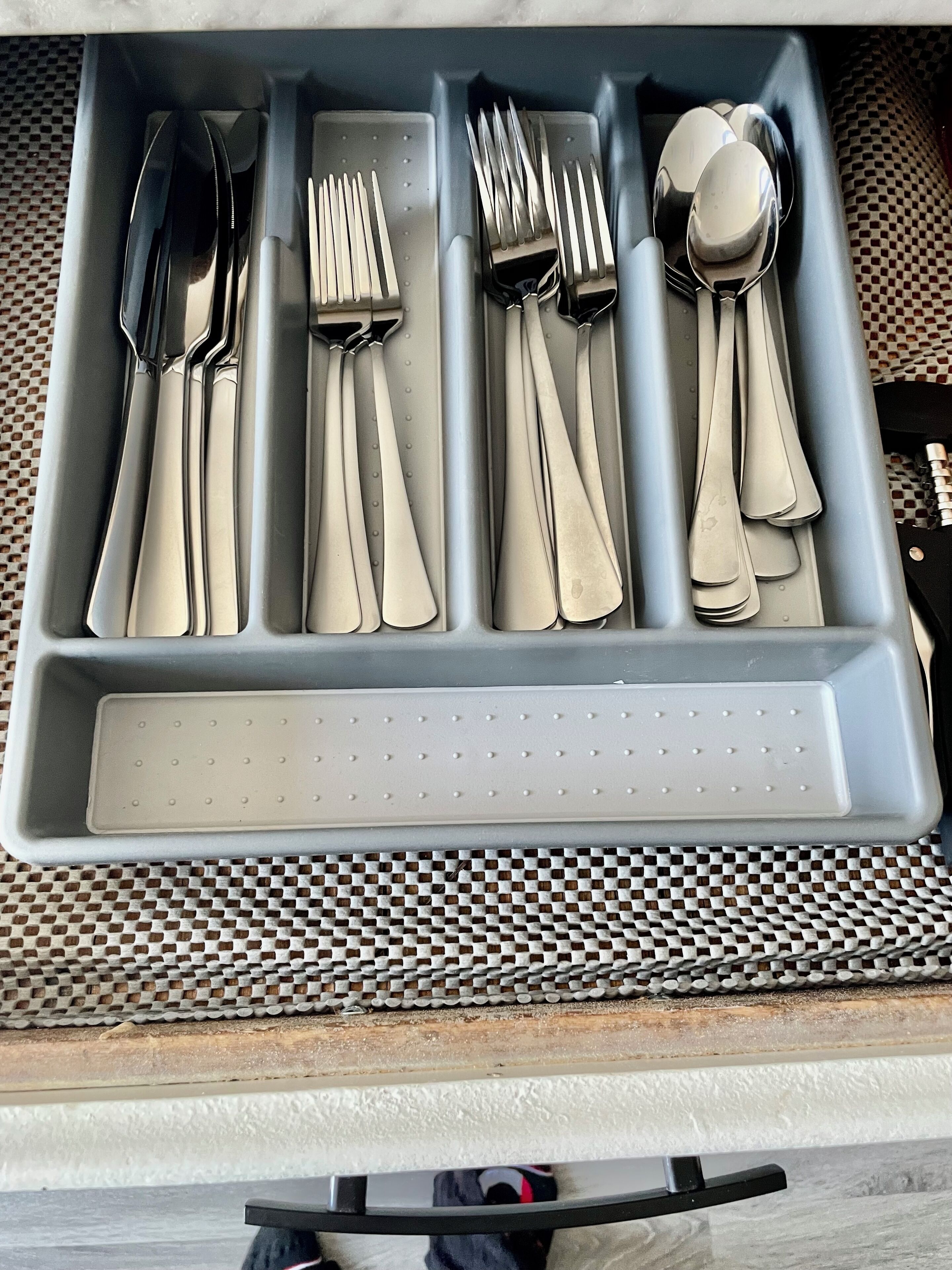 A drawer with utensils including forks, knives, and spoons.