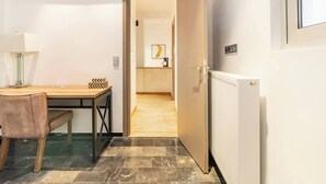A room with a wooden table, a chair, a radiator, and a door leading to another room. - Serenity & Luxury - Elegant 2BR in Kifisia's Center (Kifisia)