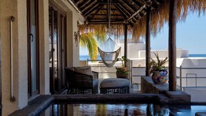 A poolside area with a hammock, seating, and a view of the ocean. - Infiniti Pool-View of Arch, Oceanview-Walk to Beach, Cape Hotel, Close to Dwntn  (Cabo San Lucas)