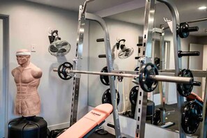 Ein Fitnessraum mit Gewichten, einer Bank und einer Schaufensterpuppe.