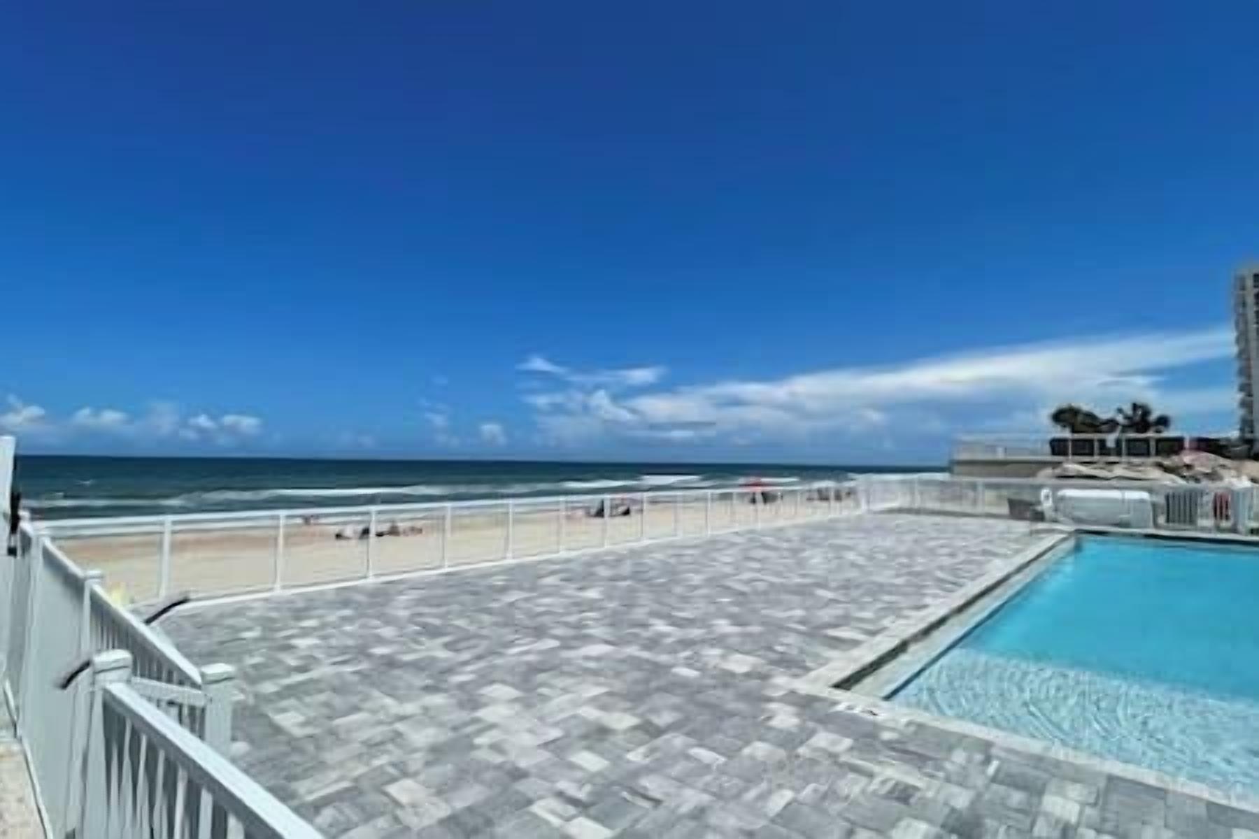Una piscina al terrat amb vista a la platja i a l'oceà.