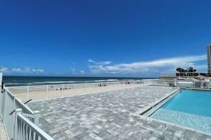 Une piscine sur le toit offrant une vue sur la plage et l’océan.