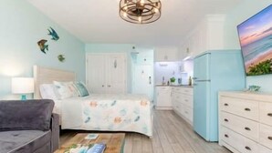 Un dormitorio con cama, mesita de noche, cómoda y un cuadro en la pared.