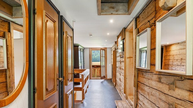 A hallway with wooden walls and doors, a bench, and a view of the outdoors. - Holiday Home "The Farm" with Mountain Views, Private Terrace & Wi-Fi (Westendorf)