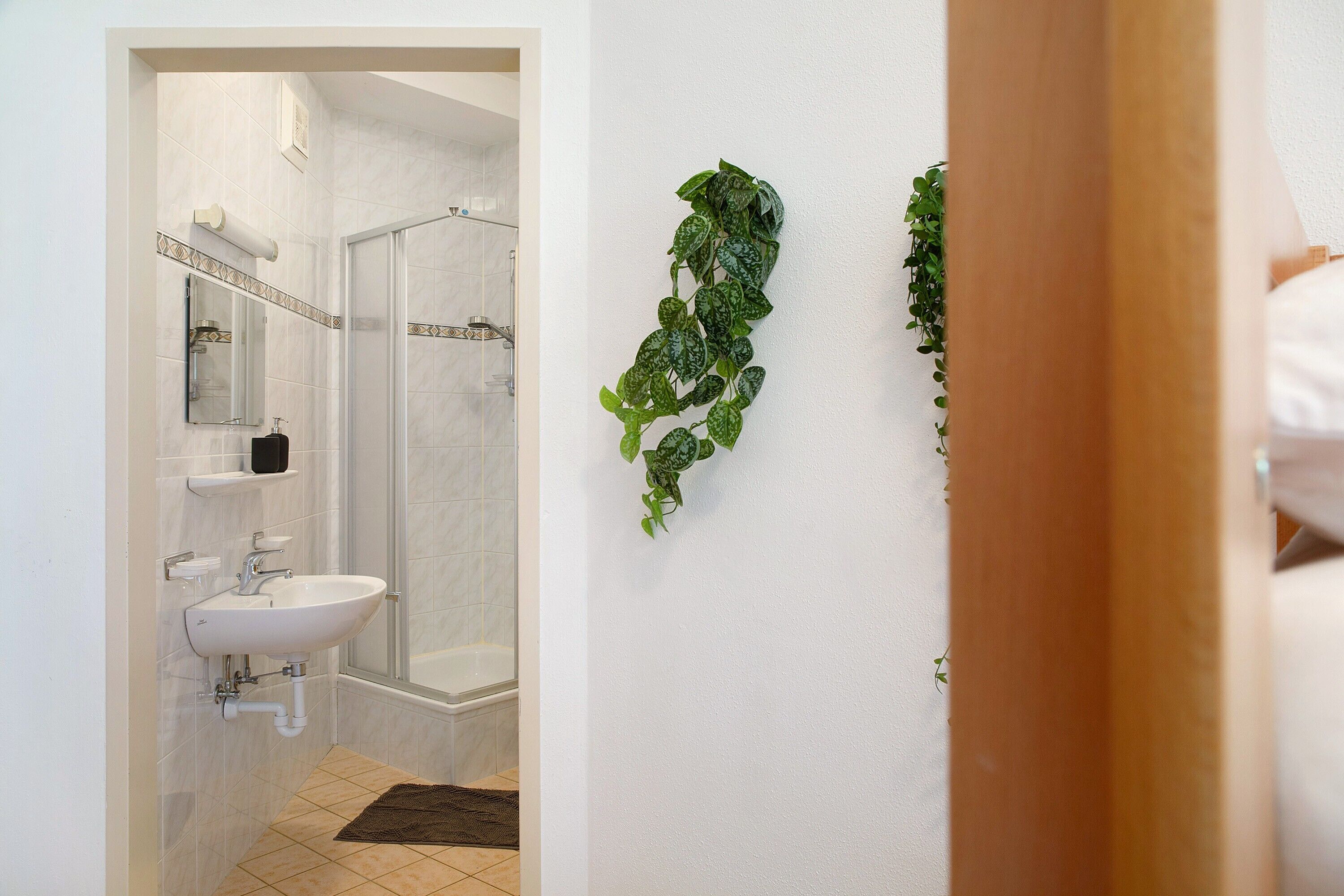 Un bagno con doccia, lavandino e specchio.