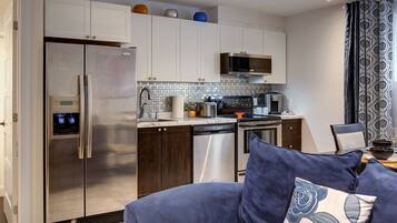 A modern kitchen with stainless steel appliances, a built-in microwave, and a dishwasher.