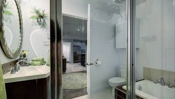 A modern bathroom with a glass shower enclosure, a white toilet, and a bathtub.