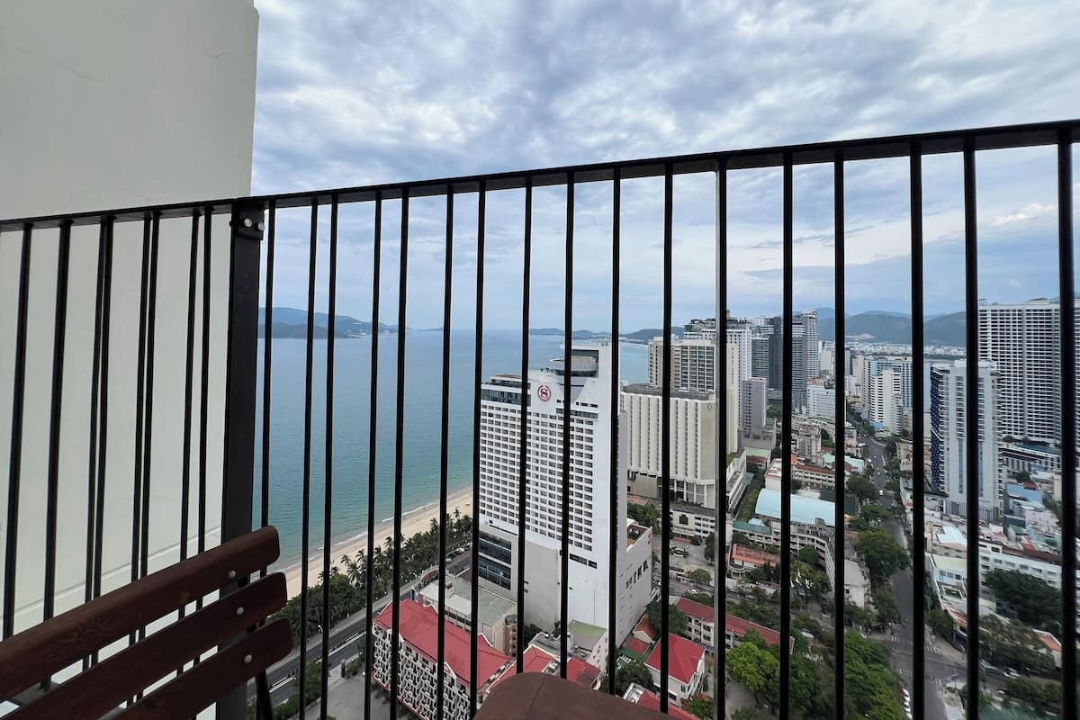 A balcony with a view of a beach and cityscape.