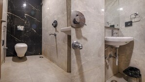 Uma casa de banho moderna com sanita, chuveiro e lavatório.