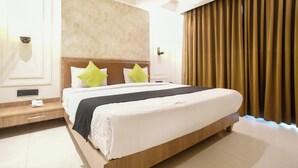 Una habitación de hotel con una cama grande, una mesita de noche y una lámpara de pared.