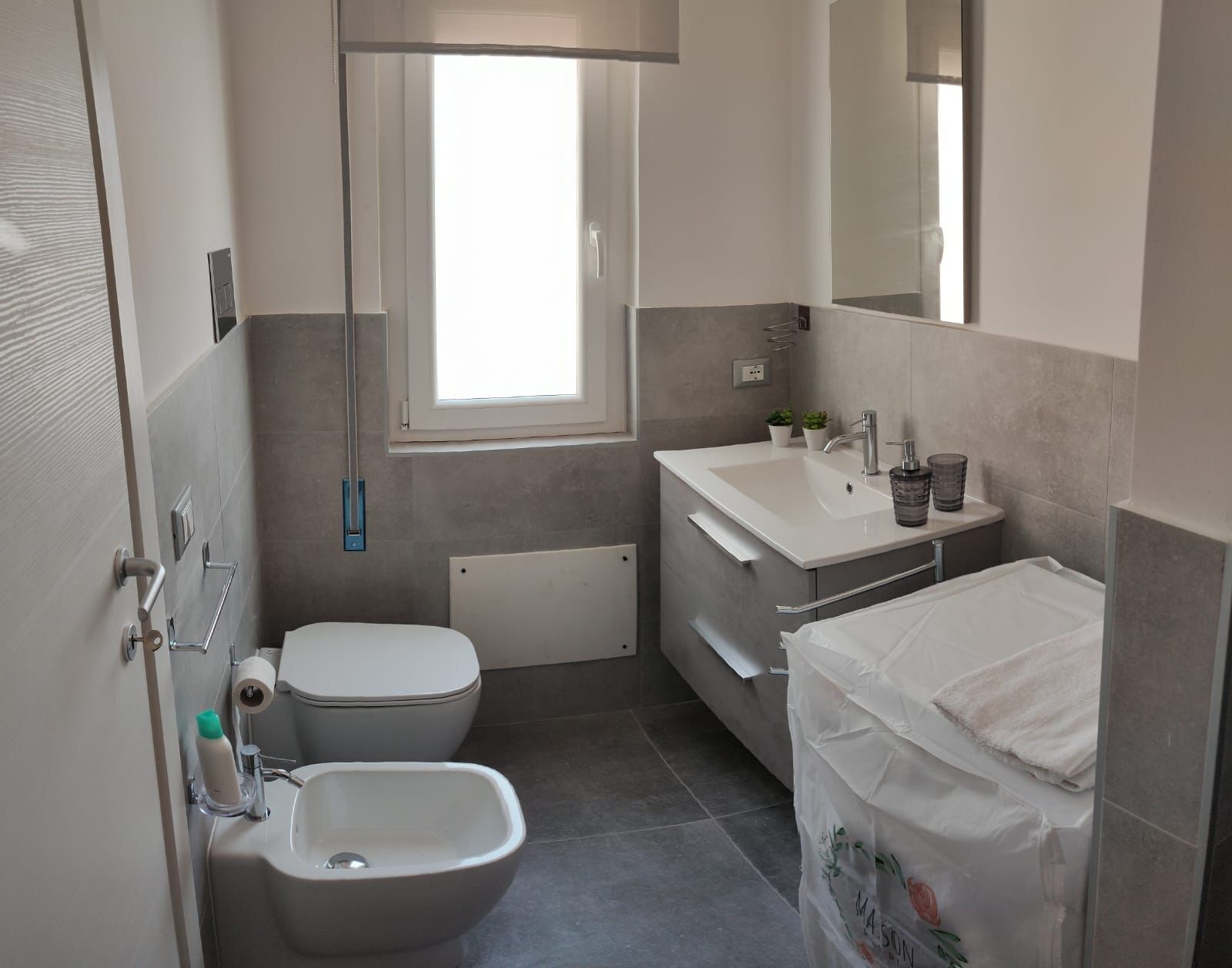Une salle de bain moderne équipée de toilettes, d’un bidet, d’un lavabo et d’une douche.