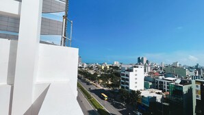 A cityscape with modern buildings, a clear blue sky, and a road with vehicles. - Rivera Boutique (Da Nang)